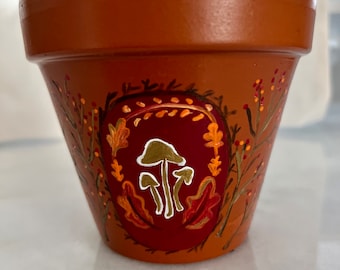Maceta de terracota con forma de hongo de otoño pintada a mano
