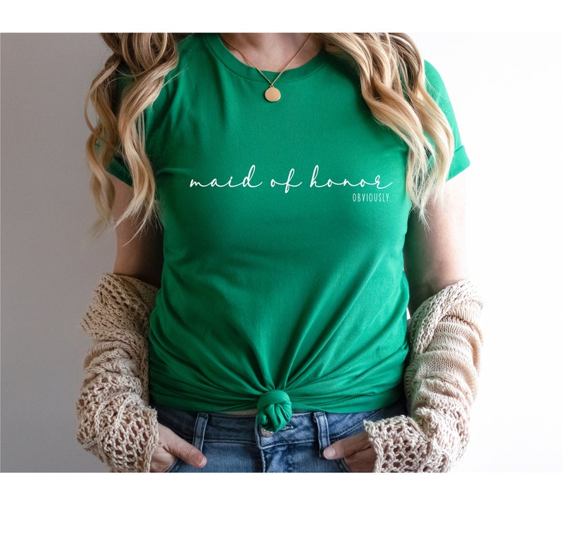 May include: A green t-shirt with the text "maid of honour obviously" in white script.