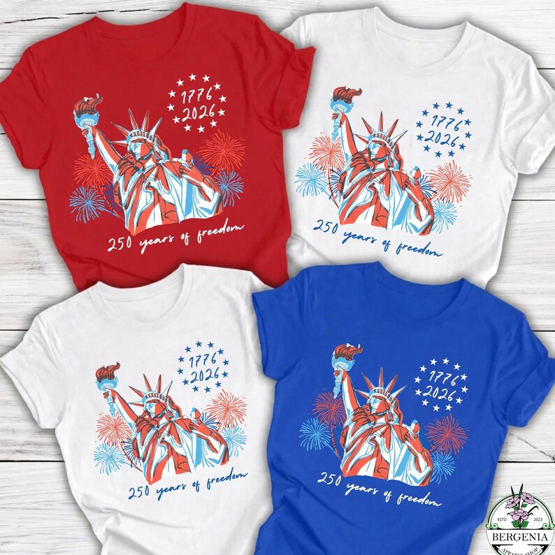 May include: Four short-sleeved t-shirts in red, white, and blue, each featuring a graphic of the Statue of Liberty holding a torch, with fireworks and text that reads "1776 *2026*" and "250 years of freedom."