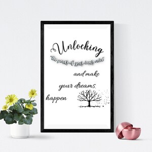 Peut inclure: Impression encadrée avec les mots « Unlocking the power of your inner voice and make your dreams happen ». L'impression a un cadre noir et un graphisme d'arbre minimaliste. Une petite plante en pot avec des fleurs jaunes est à gauche.