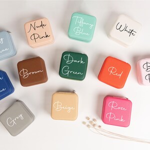 May include: Twelve small square boxes in various colors with white lettering. The boxes are labeled with colors such as Sky Blue, Nude Pink, Tiffany Blue, White, Dark Green, Red, Royal Blue, Brown, Grey, Beige, Rose Pink, and Baby Pink.