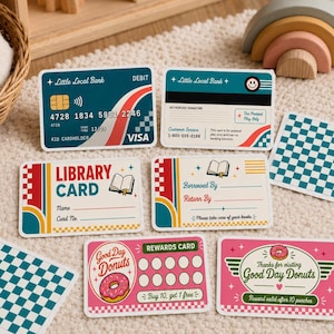 Könnte beinhalten: Eine Sammlung farbenfroher Spielkarten, darunter eine Debitkarte, eine Bibliothekskarte und Prämienkarten. Die Debitkarte ist türkis mit dem Text "Little Local Bank" und "VISA". Die Bibliothekskarte trägt den Text "LIBRARY CARD". Die Prämienkarten tragen die Aufschrift "Good Day Donuts".