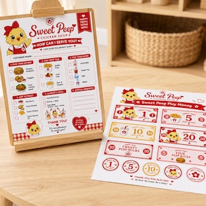 May include: A wooden Sweet Peep Chicken Shop menu board with a red and white checkered border, featuring a cartoon chick mascot. Beside it, play money with the same mascot and denominations of 1, 5, 10, and 20.