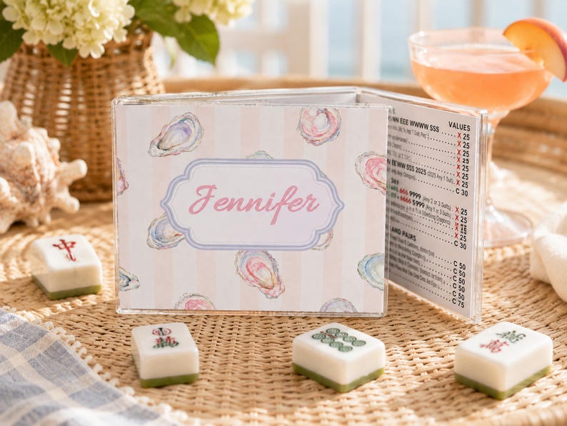 May include: A clear acrylic menu holder with a pink and white striped design, featuring watercolor oyster illustrations. The holder displays a menu with pricing and the name "Jennifer" in pink script. Several Mahjong tiles are in the foreground.