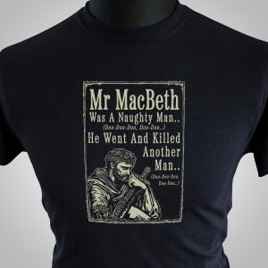 Peut inclure: Un t-shirt noir avec un graphique blanc d'un homme avec une épée. Le graphique comprend le texte "Mr MacBeth Was A Naughty Man... (Doo-Doo-Doo, Doo-Doo..) He Went And Killed Another Man.. (Doo-Doo-Doo, Doo-Doo..)"