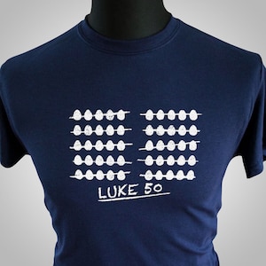 May include: A navy blue t-shirt with a white graphic of a row of eggs and the text "LUKE 50".