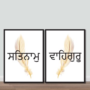 May include: Two framed prints with white backgrounds and black frames. Each print features a golden feather with a black word in Punjabi script. The left print says "ਮਿਤਰਤਾ" and the right print says "ਦਇਆ".