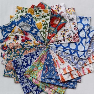 May include: A collection of colorful fabric napkins with floral and geometric patterns. The napkins are arranged in a circle, with the edges of each napkin overlapping the next.
