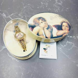 Reloj de señora renacentista con querubín vintage pero nuevo en caja, colección de ángeles de Avon, reloj analógico con pintura de Rafael, regalo para mujer, NECESITA BATERÍA