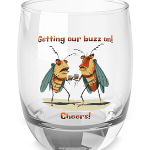 May include: A clear glass tumbler with a humorous illustration of two cartoon bugs drinking and the text "Getting our buzz on! Cheers!"