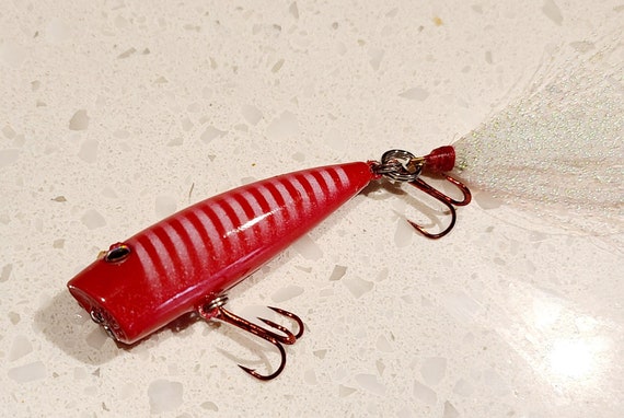 Eco-friendly, Custom Painted Topwater Popper Bass Lure Sure to Catch Fish.  Super Sharp Treble Hooks and Comes in a Metal Tin Gift Box 