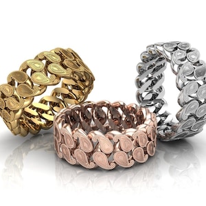 Peut inclure: Trois bagues en or, argent et or rose avec un motif paisley. Les bagues sont empilées les unes sur les autres.