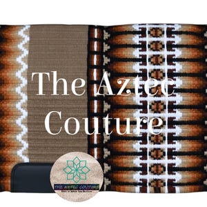 Puede incluir: Una manta de silla rectangular con un diseño de inspiración azteca. La manta presenta un panel central marrón claro, bordeado por patrones geométricos marrones y blancos. El texto "The Aztec Couture" se muestra de forma destacada.