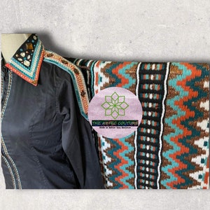 Pode incluir: Uma camisa preta com uma borda de contas turquesa e laranja. A camisa tem um colar decorativo com strass e contas. A camisa &eacute; combinada com um cobertor estampado em turquesa, laranja, marrom e branco com o texto "THE AZTEC COUTURE Ride in What You Believe".