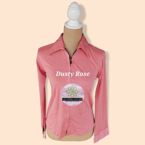 May include: Dusty rose long-sleeve shirt with a zipper closure and a small logo on the front that says "The Aesthetic Couture,  Live in What You Believe".