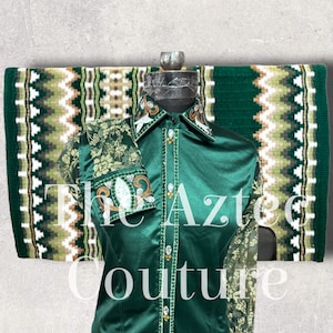 May include: A green satin shirt with a lace overlay and gold and crystal embellishments. The shirt is paired with a green and white saddle pad with a geometric pattern. The text "The Aztec Couture" is visible in the image.