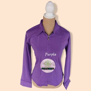 May include: Purple long-sleeve zip-up shirt with a collar. The shirt is on a white mannequin. The text "Purple" is printed on the shirt. The text "The Aesthetic Couture" is printed on a circle with a flower design.