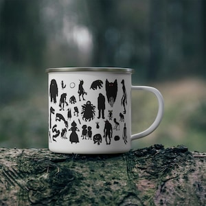 May include: White enamel camping mug with a black silhouette design of various monsters and creatures. The mug has a black handle.