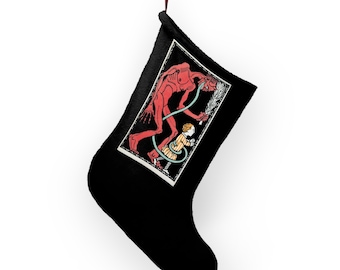 May include: Black Christmas stocking with a red hanging loop. The stocking displays a framed illustration of a red demon-like figure and a child. The illustration is in a black and white frame.