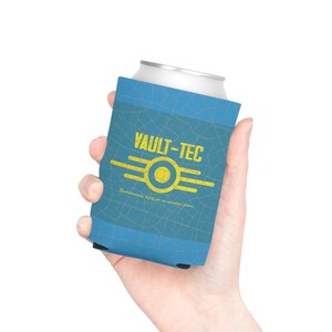 May include: A blue foam can cooler featuring a yellow Vault-Tec logo and the text "VAULT-TEC" and "Revolutionizing safety for an uncertain future." The blue surface has a subtle, dark-lined crackle pattern across the entire exterior.
