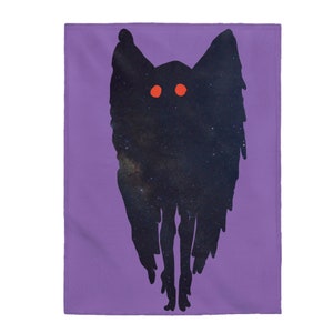 May include: A rectangular purple blanket with a black silhouette of a creature with red eyes. The creature's body is filled with a starry night sky design. The blanket is made of a soft fabric.