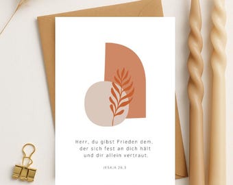 May include: A minimalist card with an abstract design in shades of orange and brown. The card features a quote in German: "Herr, du gibst Frieden dem, der sich fest an dich hält und dir allein vertraut. Jesaja 26.3"