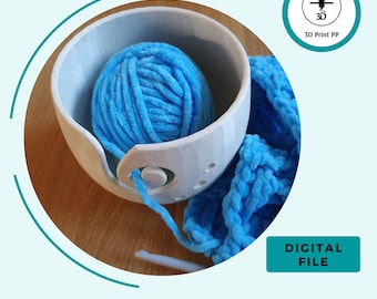 May include: A white yarn bowl with a blue yarn ball inside. The yarn bowl has a hole in the side for the yarn to feed through. A blue crocheted scarf is next to the bowl. The text "DIGITAL FILE" is on a blue rectangle.