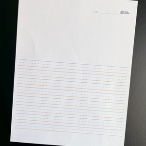 Puede incluir: Una hoja de papel blanca con líneas discontinuas azules y rojas. El papel tiene la palabra "Fecha" escrita en la parte superior con una línea en blanco para escribir la fecha.