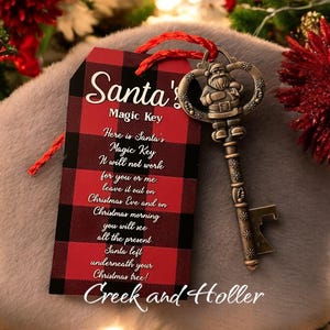 May include: A red and black plaid tag with the text "Santa's Magic Key" and a message about leaving the key out on Christmas Eve. The tag is attached to a gold-colored key with a Santa figurine on the top.