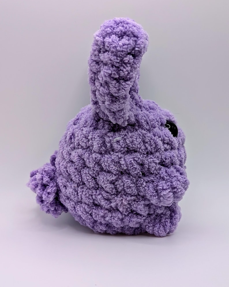 May include: A plush purple crocheted bunny with a long ear and a black button eye.