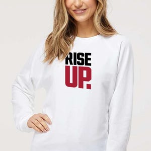 May include: White sweatshirt with a black and red graphic that says "RISE UP."