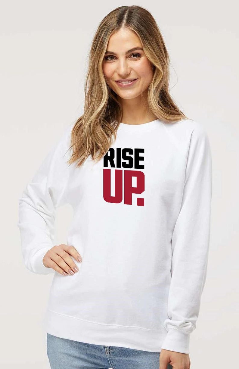 May include: White sweatshirt with a black and red graphic that says "RISE UP."