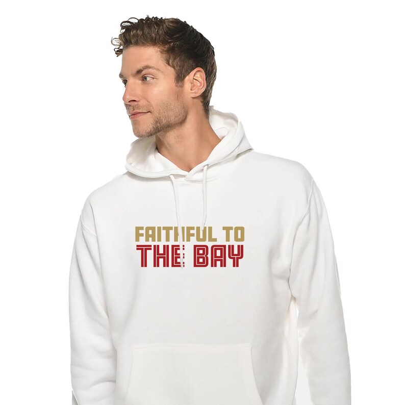 May include: White hooded sweatshirt with the text "Faithful to The Bay" in gold and red lettering.