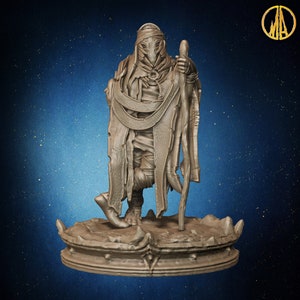 May include: A bronze-coloured figurine of a robed figure holding a staff. The figure stands on a decorative base with a textured surface. The background is a gradient of blue with small, white speckles.