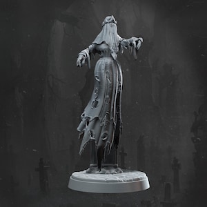 Könnte beinhalten: Graue, 3D-gedruckte Figur einer geisterhaften Frau. Sie trägt ein langes, zerfetztes Kleid und einen Schleier, mit ausgestreckten Armen. Die Figur steht auf einem kleinen, runden Sockel, mit einer Friedhofsszene im Hintergrund.