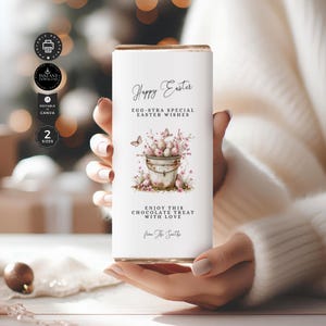 May include: A white chocolate bar wrapper with a watercolor illustration of a bucket filled with Easter eggs and pink flowers. The text on the wrapper reads "Happy Easter, Egg-stra Special Easter Wishes, Enjoy this Chocolate Treat with Love, from The Smiths."