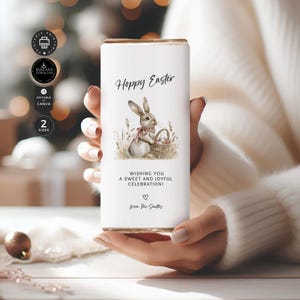 May include: A white chocolate bar wrapper with a watercolor illustration of a bunny holding a basket of eggs. The text "Hoppy Easter" is at the top of the wrapper. The text "Wishing you a sweet and joyful celebration!" is below the bunny. The text "from The Smiths" is at the bottom of the wrapper.