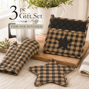 May include: A 3-piece kitchen gift set featuring a black and tan checkered oven mitt, pot holder with a black star, and a star-shaped trivet. The set includes the text "3 pc Gift Set For His Kitchen".