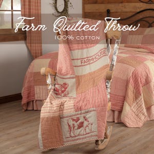 May include: A red and cream-colored farm-style quilted throw draped over a wooden rocking chair. The throw features a patchwork design with stripes and farm animal illustrations. The text "Farm Quilted Throw" and "100% Cotton" are visible.