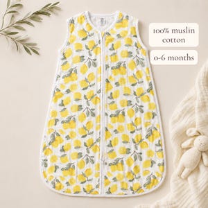 A yellow and green baby onesie with a lemon pattern, placed on a white background.