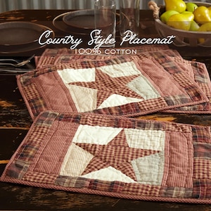 May include: Country style placemats made of 100% cotton. The placemats feature a patchwork design with a large star in the center. The color scheme includes red, white, and brown tones, with a plaid border. The text "Country Style Placemat" is visible.