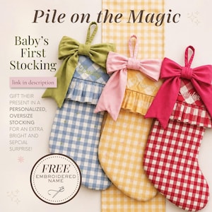 The image is an advertisement for a "Baby's First Stocking" that features three colorful, embroidered stockings with bows. The text on the image includes "Pile on the Magic" and "Baby's First Stocking" along with a description of the product, which is a personalized, oversized stocking for an extra bright and special surprise. The ad also includes a free embroidered name and a free embroidery kit.