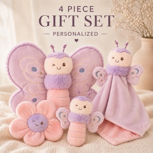 May include: A 4 piece personalized gift set featuring plush toys in shades of lavender and soft pink. The set includes a large butterfly, a smaller butterfly, a flower-shaped toy, and a butterfly-themed security blanket, all with embroidered faces.