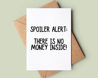 May include: A white card with black text that reads "Spoiler Alert: There is no money inside!" The card is sitting on a brown envelope.