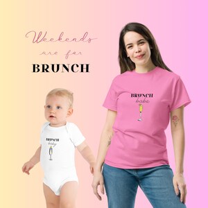 May include: A pink t-shirt with the text "BRUNCH babe" and a glass of champagne. A white onesie with the text "BRUNCH baby" and a glass of champagne. The text "Weekends are for BRUNCH" is at the top of the image.
