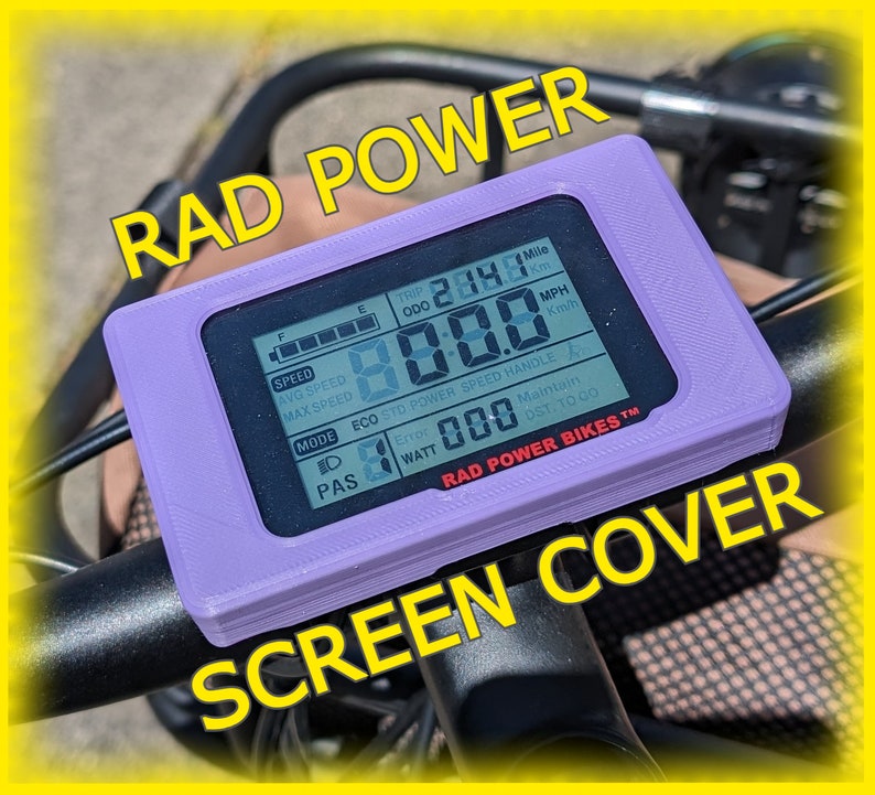 以下が含まれることがあります： Rad Power Bikes 電動自転車のディスプレイ用の紫色のプラスチック製スクリーンカバー。ディスプレイには速度、走行距離、その他の情報が表示されます。スクリーンカバーのテキストには「RAD POWER BIKES&trade;」と表示されています。