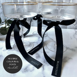 Lazos para colocar los lugares de la boda y etiquetas para bebidas: nombres con cintas impresas para una decoración moderna: tarjetas para colocar los lugares y etiquetas para bebidas con cintas de satén impresas