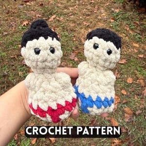 May include: Two handmade crochet sumo wrestler dolls. One has a red skirt, the other a blue skirt. Both have black hair and black eyes. The dolls are cream-coloured and the text "CROCHET PATTERN" is at the bottom.