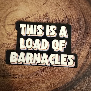 May include: Black and white sticker with the text "This is a load of barnacles" in a retro, 3D style.