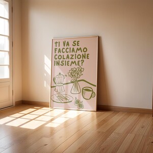 May include: A pink poster with green text and illustrations. The text reads "Ti va se facciamo colazione insieme?" which translates to "Do you want to have breakfast together?" The poster features a coffee pot, a plate with cutlery, a vase of flowers, and a cup of coffee.
